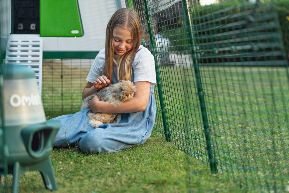 Meisje met een kip in de Omlet Eglu Cube ren