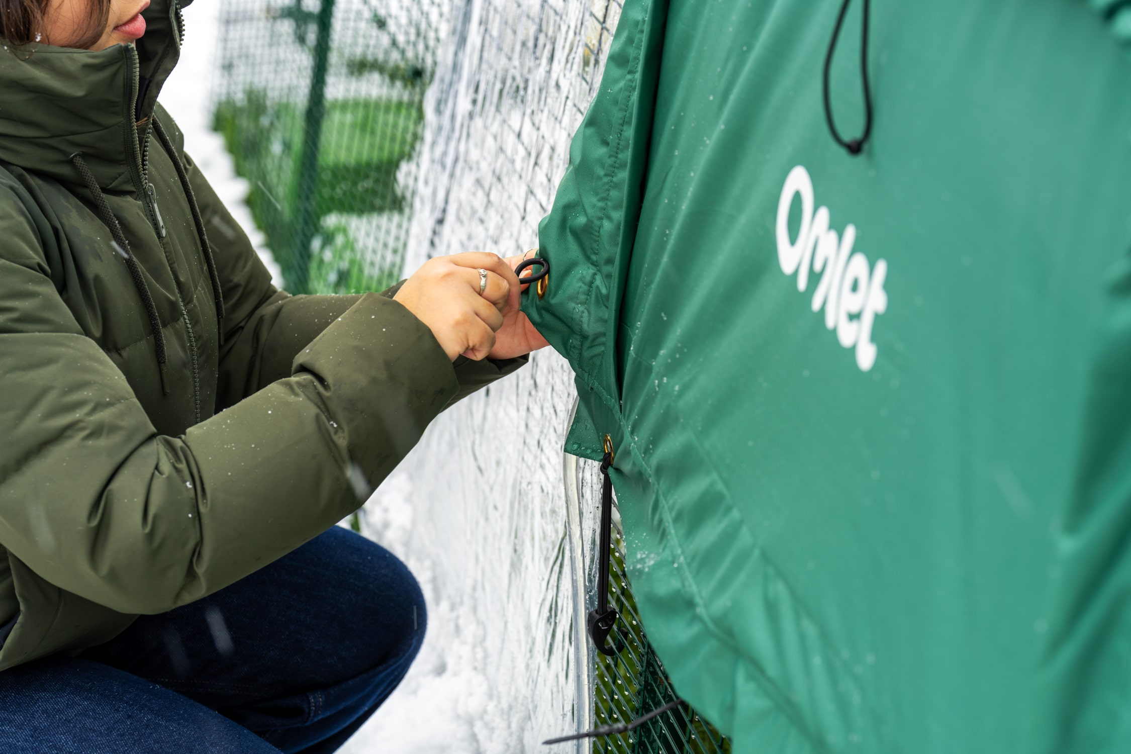 vrouw die een thermohoes aan een Eglu Pro vastmaakt
