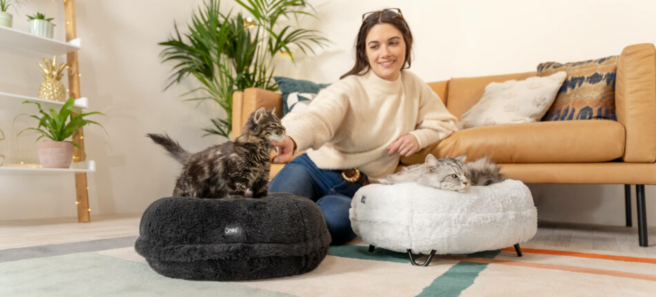 Vrouw die katten aait die slapen op Omlet Maya donutbedden