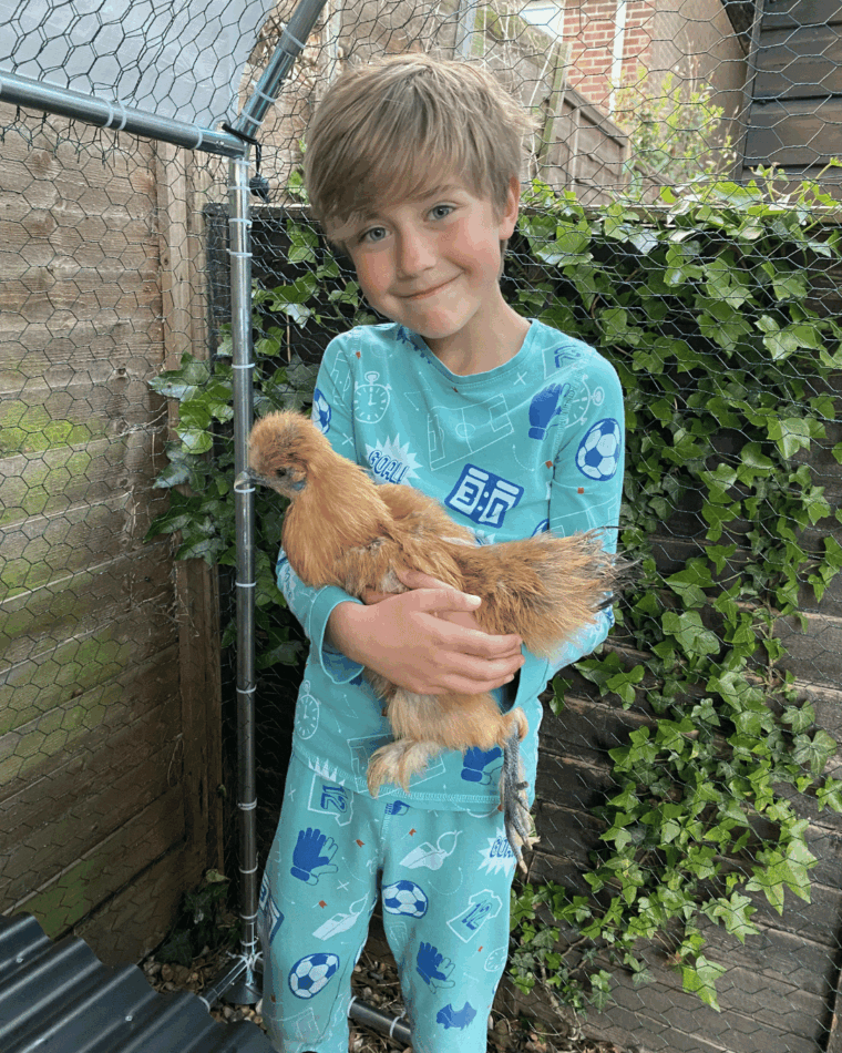 jonge jongen die een kip vasthoudt