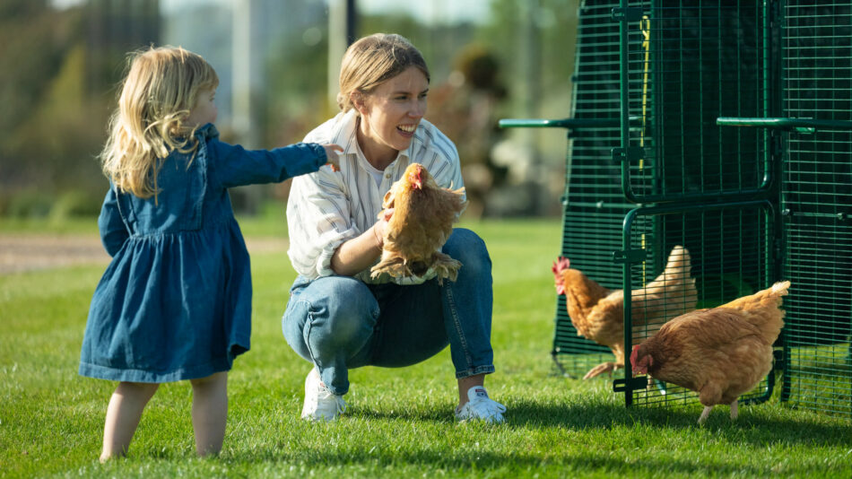 vrouw en meisje met kippen buiten de Eglu Pro